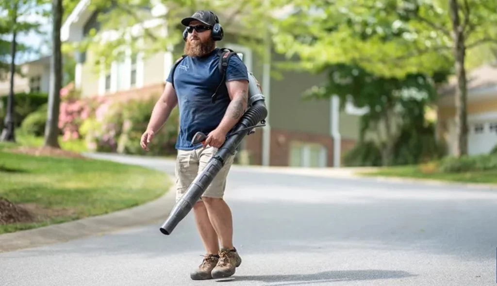 Man using leaf blower on suburban street