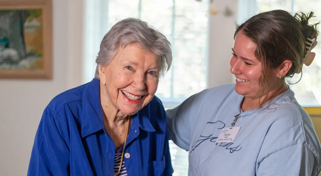 Caregiver smiling with woman indoors