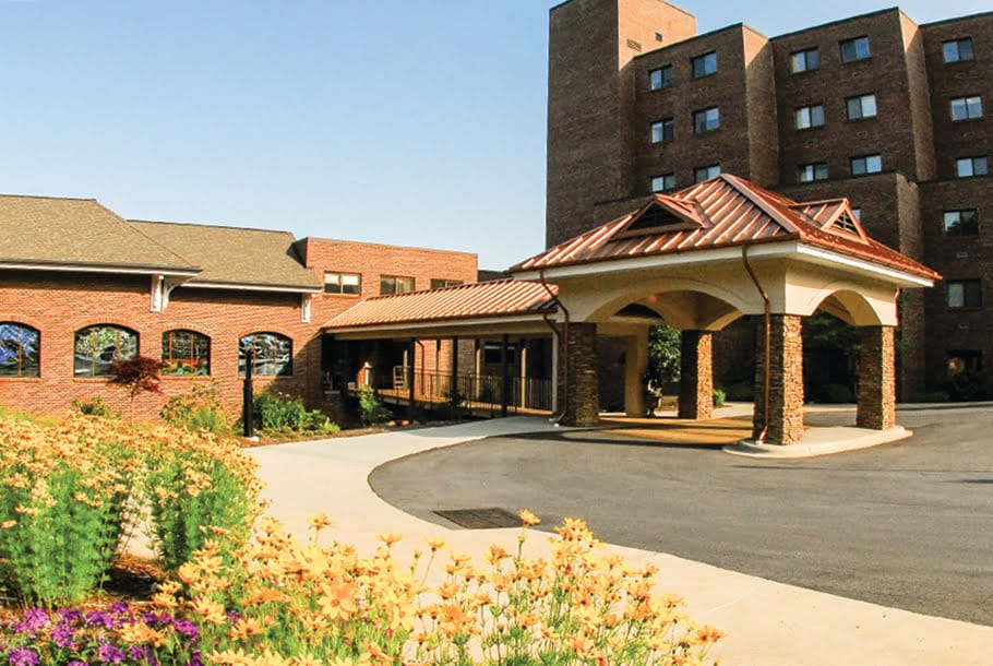 Brick building with covered entrance and garden