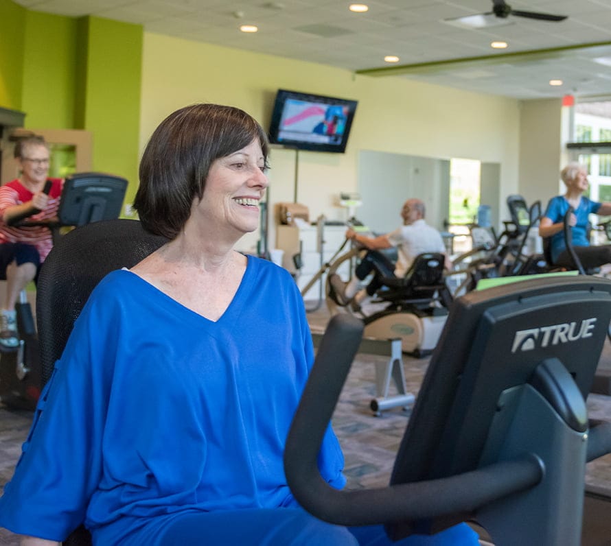 Older adults exercising on stationary bikes in gym