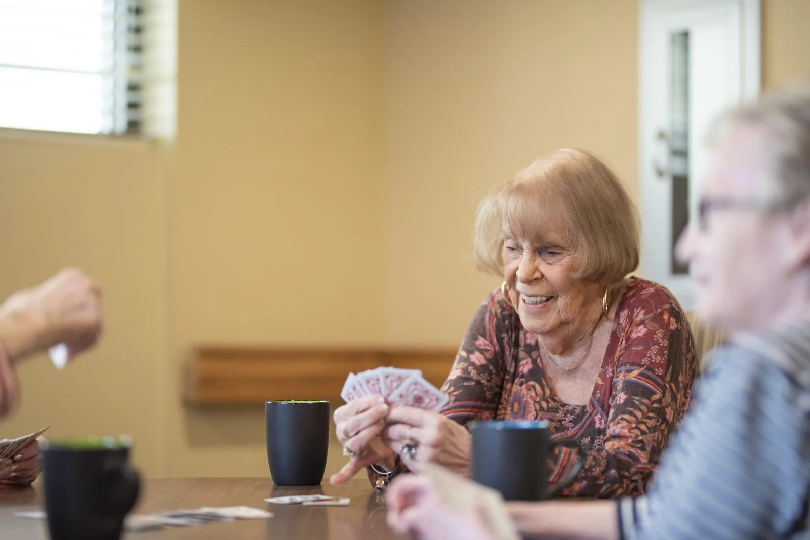 Senior women playing cards together happily