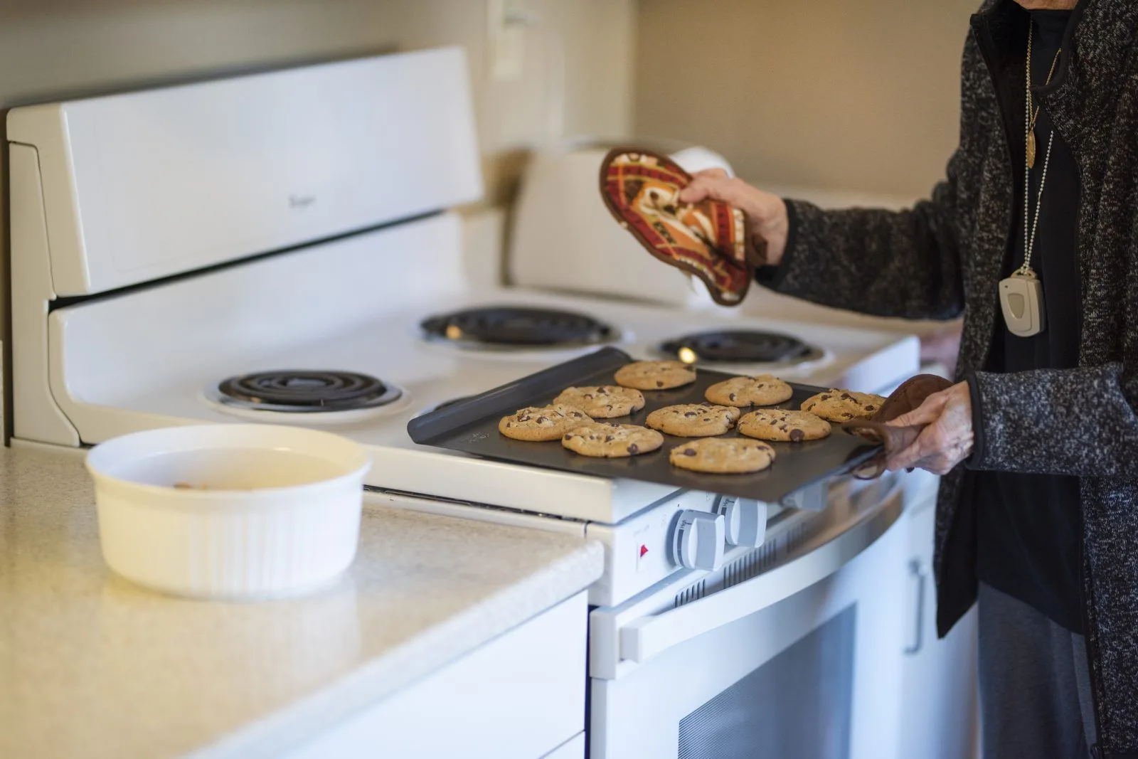 Person baking chocolate chip cookies in kitchen