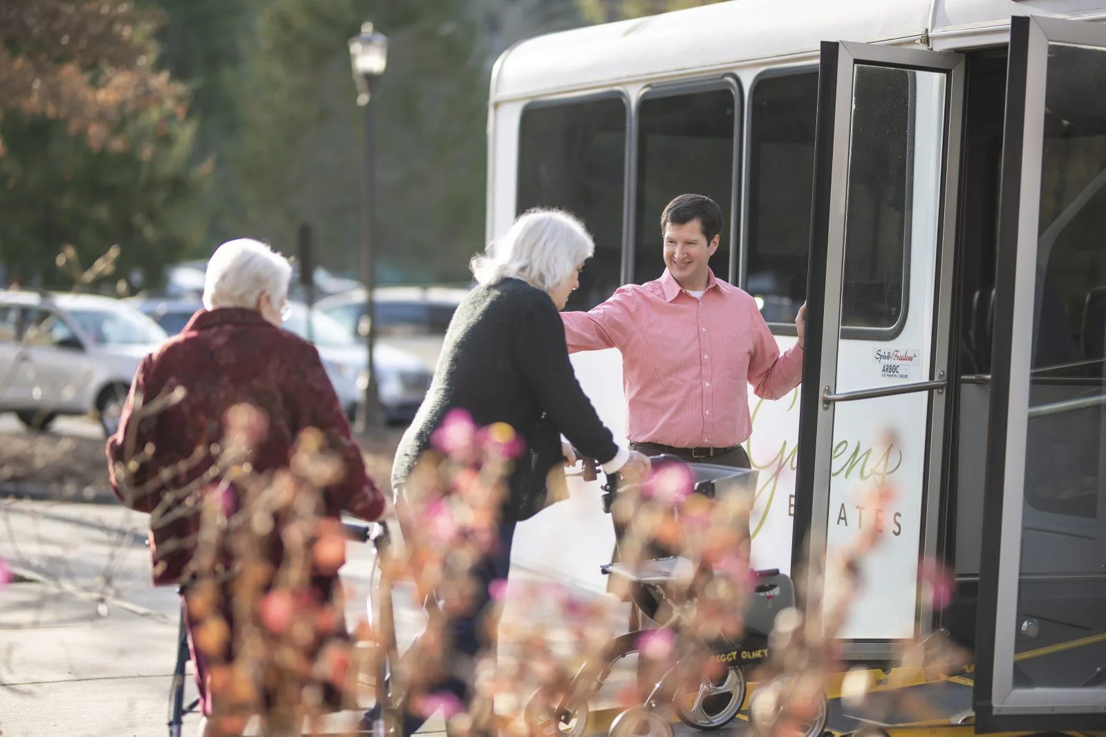 Man helping seniors board community shuttle bus