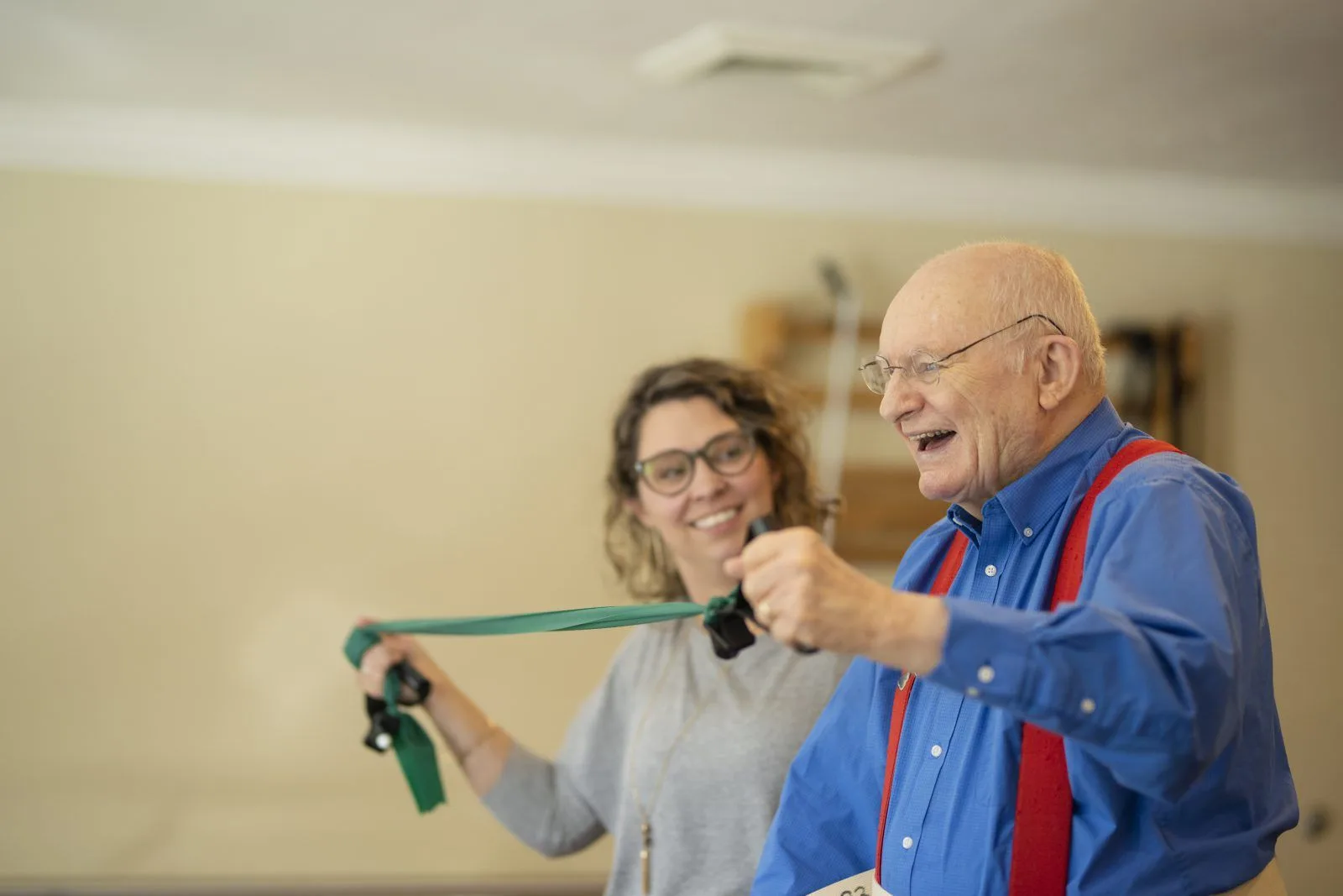 Therapist helping man exercise with resistance band
