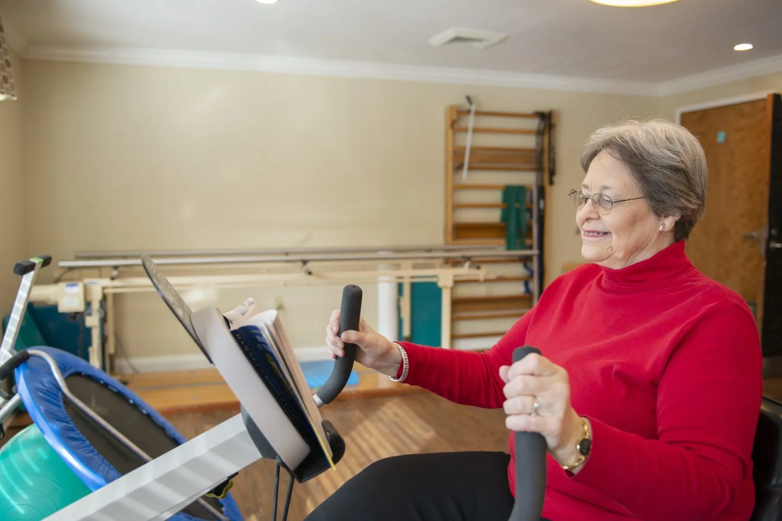 Senior woman exercising on stationary bike indoors