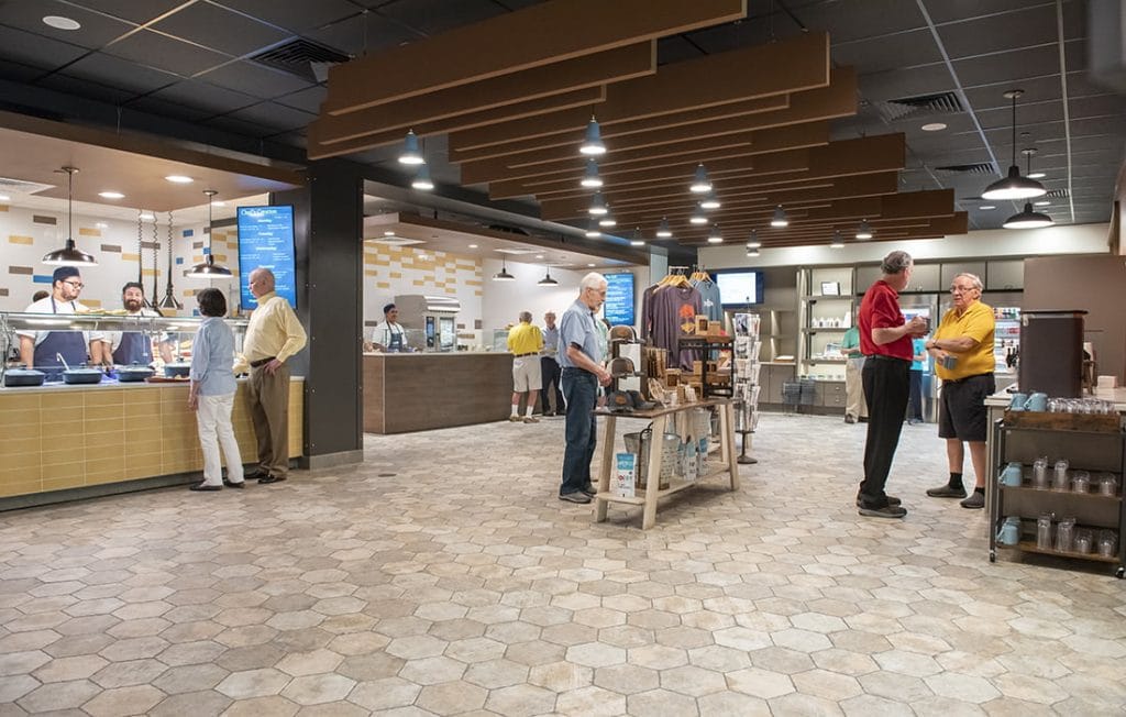People dining and shopping in a modern cafeteria.