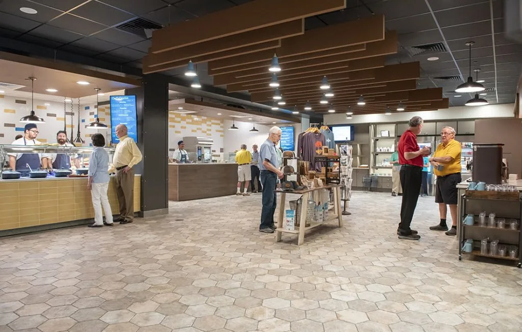 People dining and shopping in a modern cafeteria.
